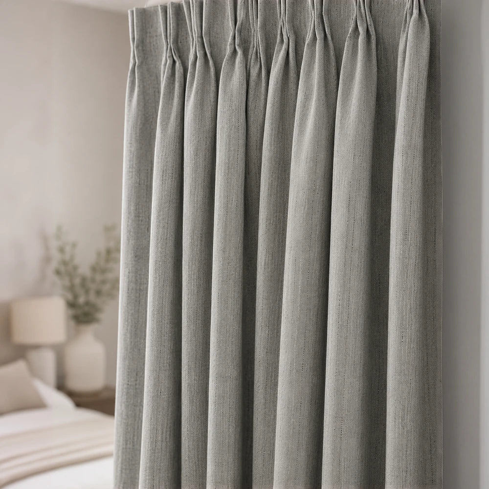 Textured blockout window curtain in soft gray with thick fabric and pleated top, designed to darken rooms and add a neutral,