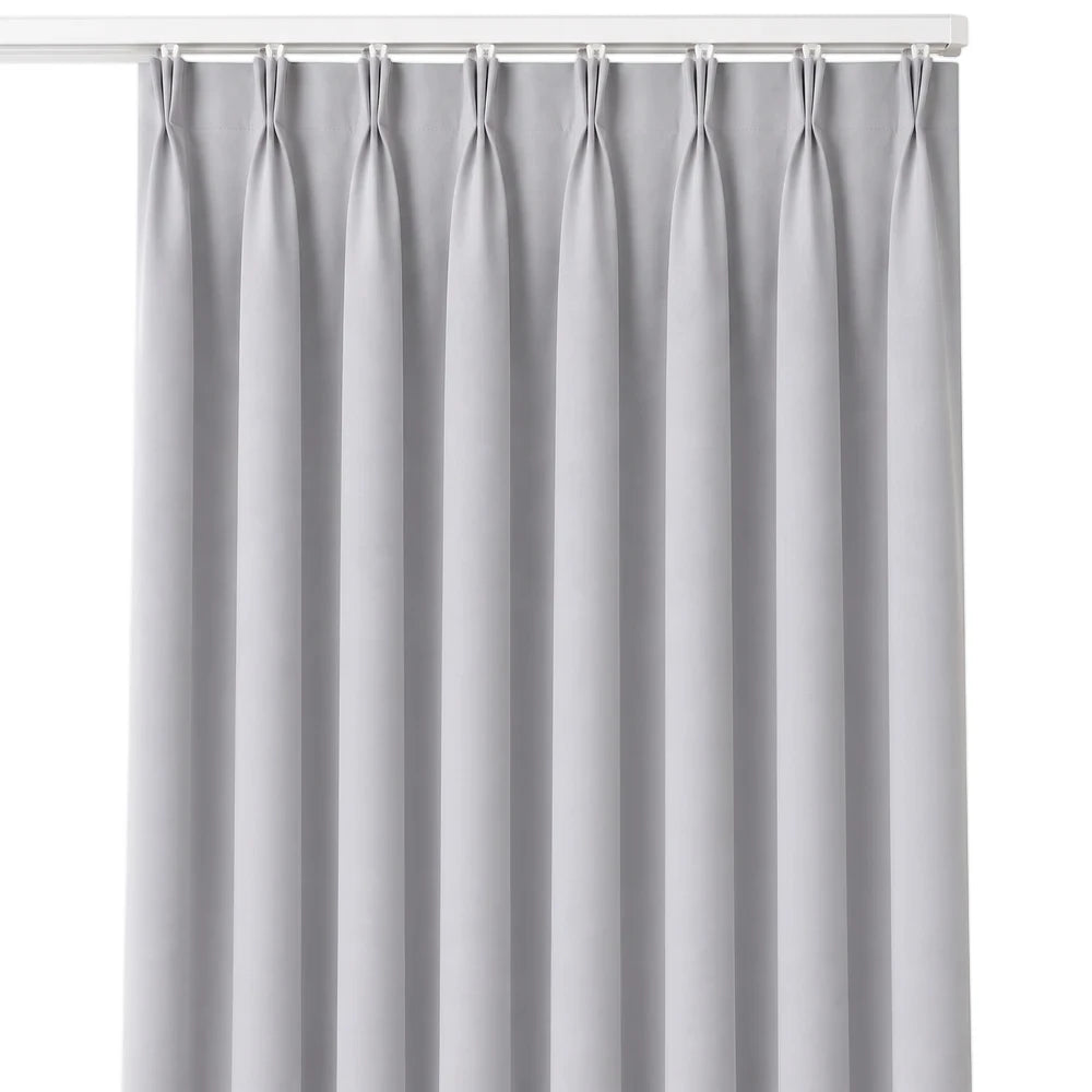 The Bahamas unlined taped curtain in light gray, featuring vertical pleats and white hanging clips.