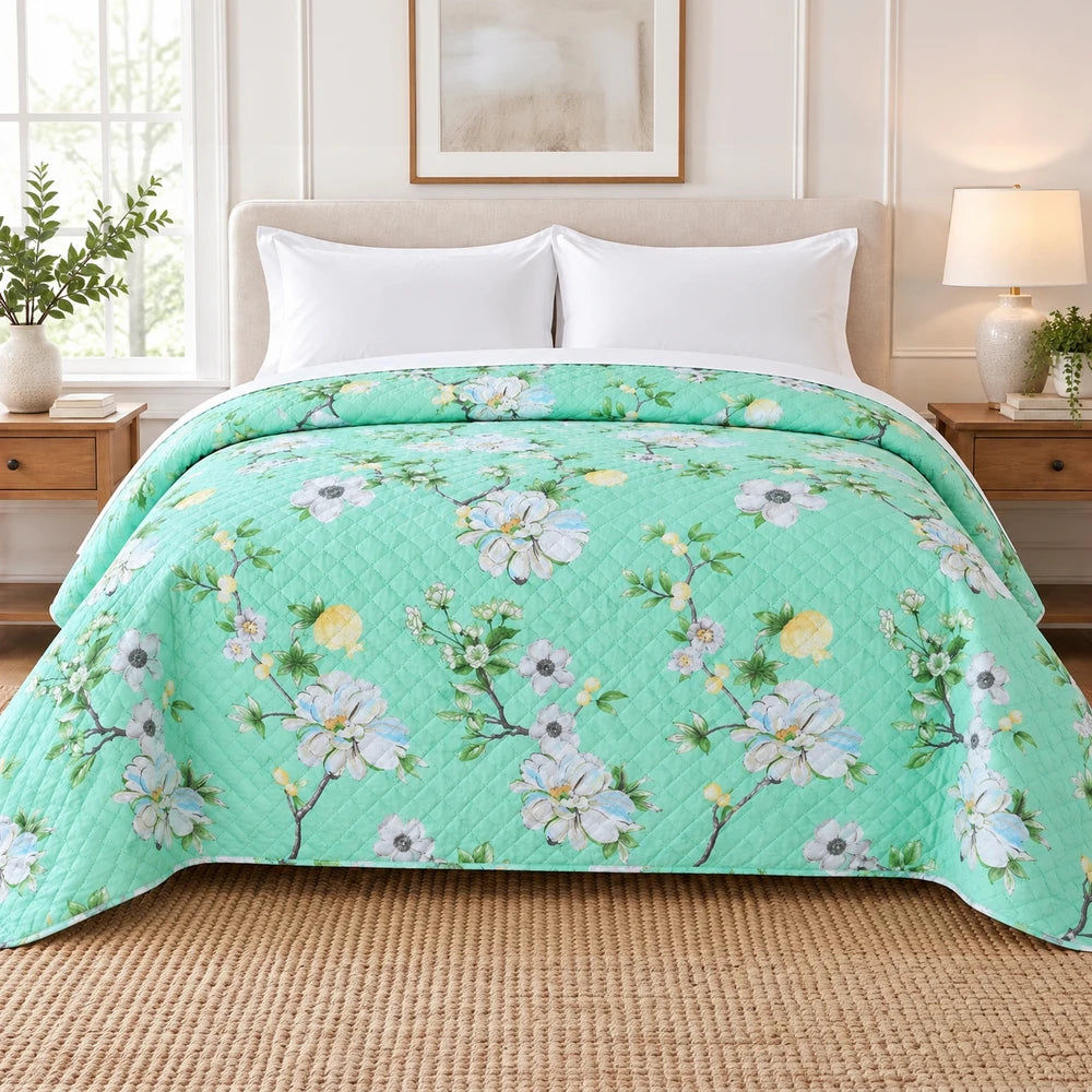 Ultrasonic 1-Piece Printed Quilt in turquoise with a white and yellow floral pattern, 220 x 200 cm, shown neatly on a bed.