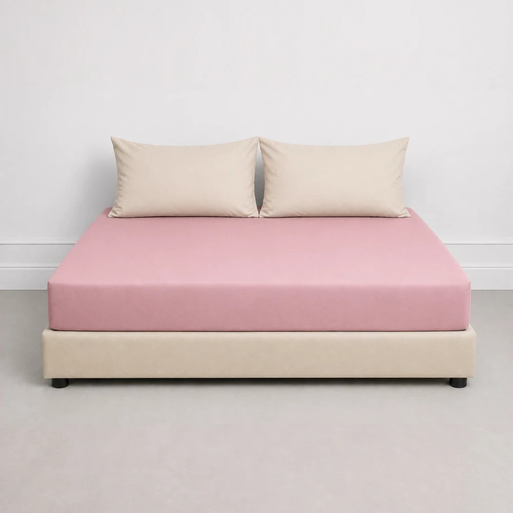 Whisper Soft Microfibre Fitted Sheet in pink, displayed on a bed with beige pillows, highlighting smooth fabric and snug fit.