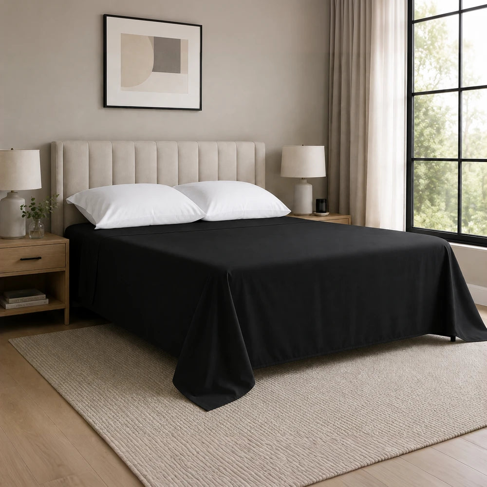 Whisper Soft Microfibre Flat Sheet in black, smooth and breathable, showcased on a neatly made bed with white pillows.